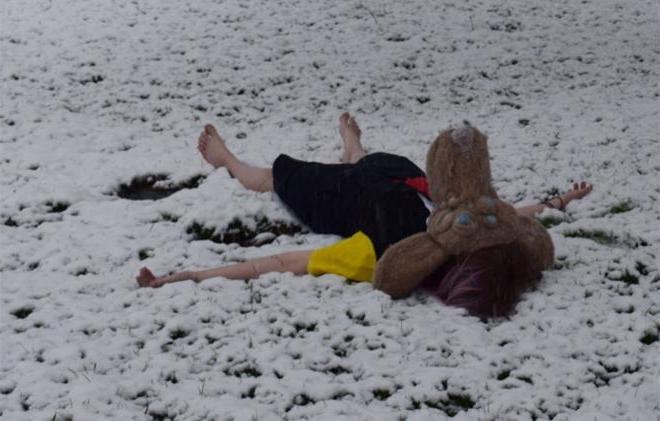 一个人躺在雪地里，穿着衣服，戴着动物面具.