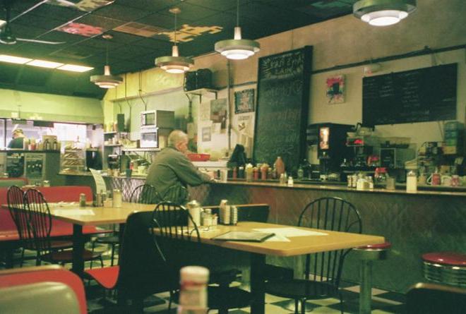 一张男人坐在餐厅吧台的照片. 