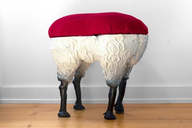 一个有红色垫子和羊腿的凳子. 