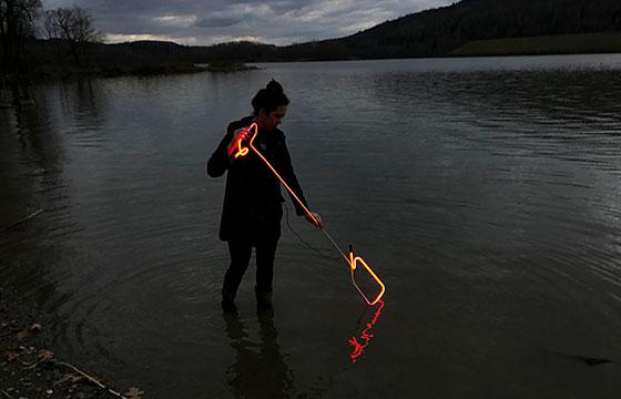 黄昏时分，女人站在湖中，拿着热玻璃或霓虹灯. time lapse